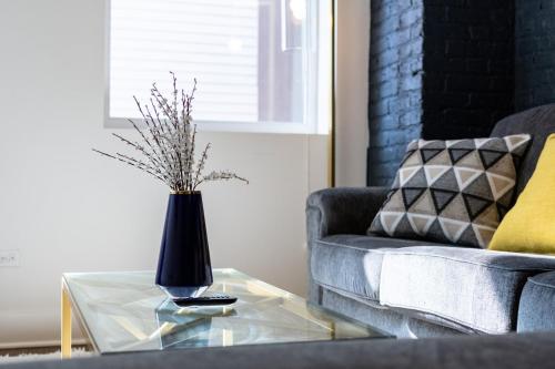 a living room with a vase on a glass table at Stylish Cozy 3BR 420 Friendly Apartment with Gym Near McCormick Place, Grant Park and Soldier Field in Chicago