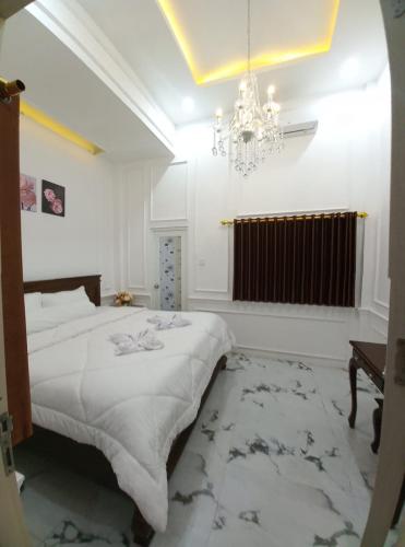 a bedroom with a large bed and a chandelier at Batu Villa Sakura in Batu