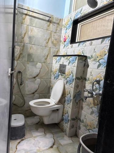 a bathroom with a toilet and a stone wall at The Human Stay in Indore