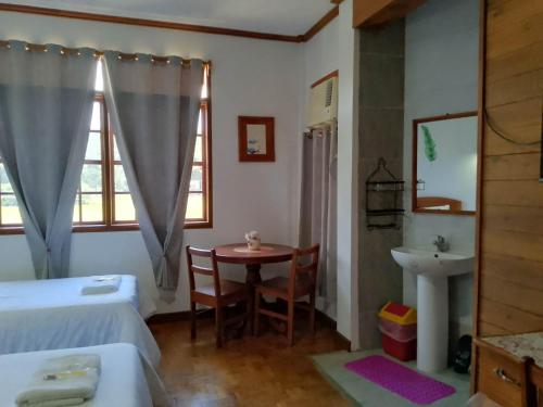 a bedroom with a bed and a table and a sink at REKWOOD Hotel in Boracay