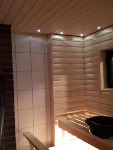 a room with a sauna with a wooden wall at Pääsky Schwalbe-cabin by crater lake in Varpaisjärvi