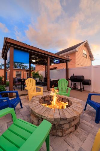 a patio with a fire pit with chairs and a grill at 3BR - Beach & Trail - Bikes, Fire Pit, Mini-Golf in St. Petersburg