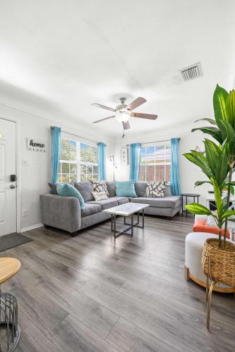 a living room with a couch and a ceiling fan at 3BR - Beach & Trail - Bikes, Fire Pit, Mini-Golf in St. Petersburg