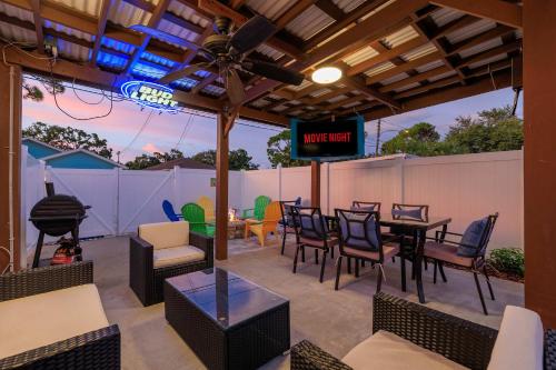 a patio with a table and chairs and a tv at 3BR - Beach & Trail - Bikes, Fire Pit, Mini-Golf in St. Petersburg
