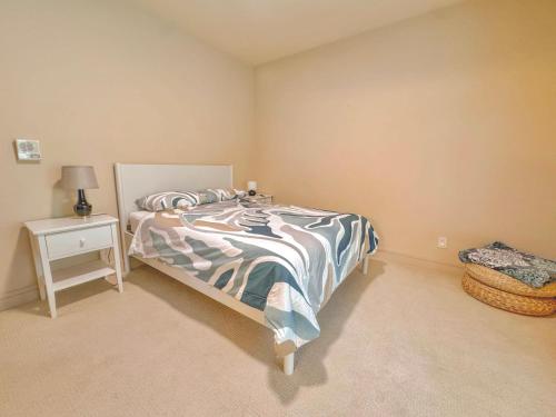 a bedroom with a bed and a night stand at Quiet Private Room with Ensuite - Broadmead 908 in Victoria