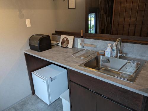 a kitchen counter with a sink and a sink at 川まで徒歩1分川沿いにある一軒宿あせみ in Nakajima