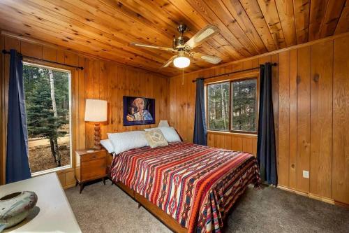 a bedroom with a bed and a ceiling fan at Charming 3-bedroom Angel Fire Cabin in Angel Fire