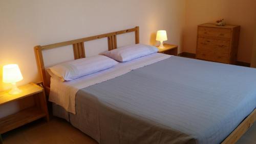 a bedroom with a large bed with two lamps on tables at Agriturismo Tenuta La Siesta in Gallipoli