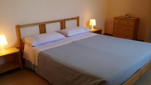 a bedroom with a large bed with two lamps at Agriturismo Tenuta La Siesta in Gallipoli