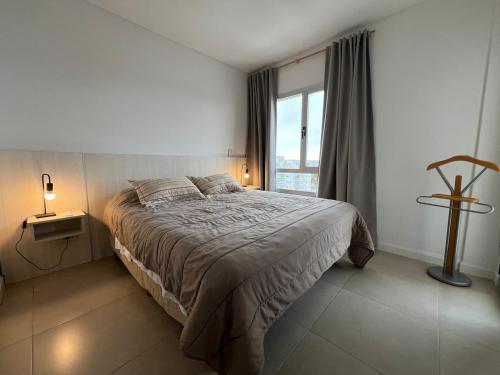 a bedroom with a large bed and a window at Punta Flecha in Puerto Madryn