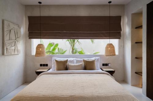 a bedroom with a large bed and a window at Heritage Villas in Uluwatu