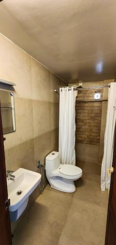 a bathroom with a toilet and a sink at Sea View Balcony room - Tide End Beach Villa in Pallipuram