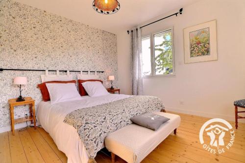 a bedroom with a large bed and a window at Le cerisier in Cancale