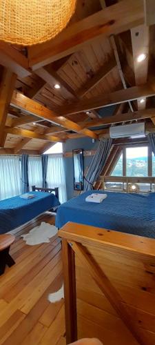 a bedroom with two beds in a room with wooden floors at Torii Cabañas de Montaña in Villa Carlos Paz