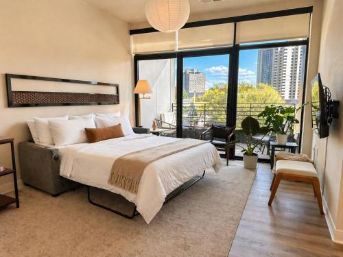 a bedroom with a large bed and a large window at East Side Luxury 1BR Apt - Near Brady St with Balcony and Lounge in Milwaukee