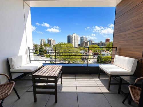 a balcony with a table and chairs and a view of a city at East Side Luxury 1BR Apt - Near Brady St with Balcony and Lounge in Milwaukee