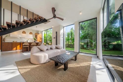 a living room with a couch and a table at Lily Villas - Rice Field Views Escape with Private Pool in Canggu