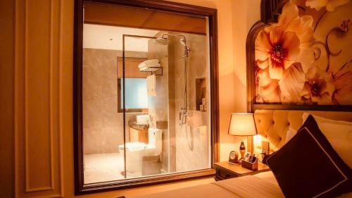 a bedroom with a shower with a glass door at Bảo Long Lào Cai Hotel in Lao Cai