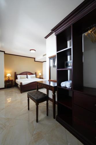 a bedroom with a bed and a desk and a table at The Vientiane Capitol "Capitol Residence" in Vientiane