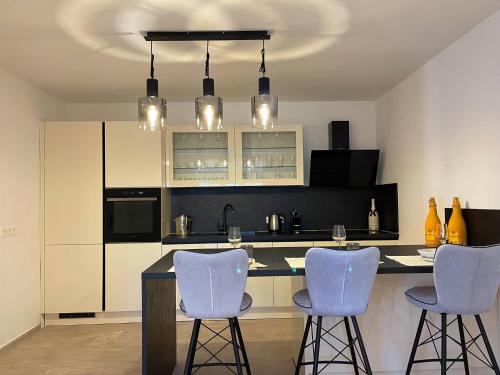 a kitchen with white cabinets and blue bar stools at Villa Olivija-in front of beach! in Stara Novalja