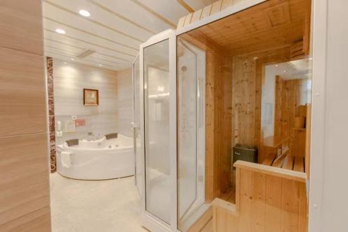 a bathroom with a shower and a bath tub at city gezhi hotel in Guancun