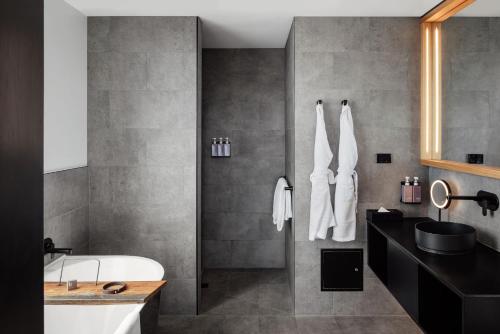 a bathroom with a white tub and a sink at Hotel Verge Launceston in Launceston