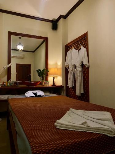 a hotel room with a bed and a mirror at The Vientiane Capitol "Capitol Residence" in Vientiane