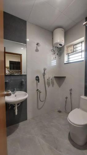 a bathroom with a toilet and a sink at Babus Serviced Apartments in Coimbatore