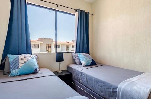a bedroom with two beds and a large window at Casa Maya in San Salvador