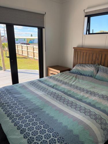 a bedroom with a bed and a view of the ocean at Whangamata Bach Life in Whangamata