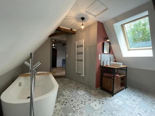 a bathroom with a large tub in a attic at Maison du causit in Aubertin