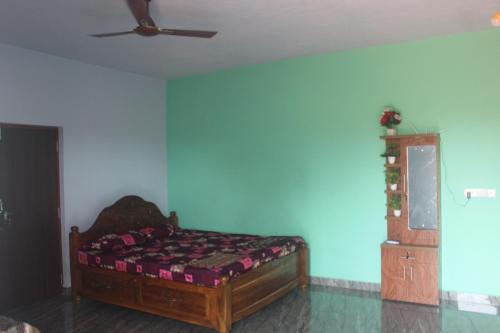 a bedroom with a bed and a ceiling fan at Harsh Guest House in Cola
