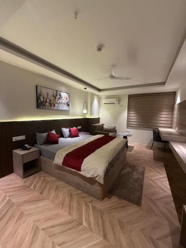 a large bedroom with a large bed and a couch at LaCasa Heights in Greater Noida