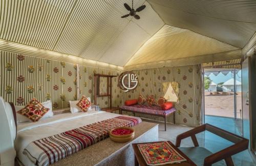 a bedroom with a large bed and a table at Gj02 desert resort in Jaisalmer