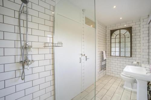 a white tiled bathroom with a shower and a sink at 2 Bed in Halesworth oc-dak in Halesworth