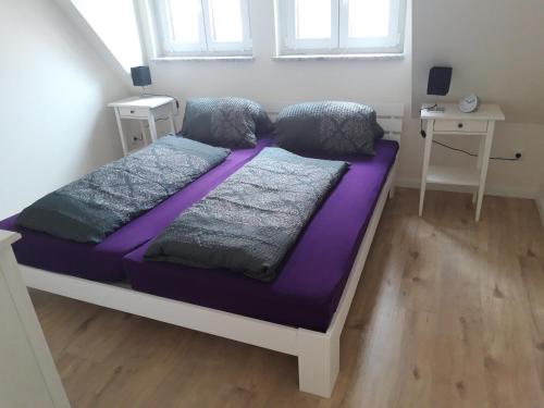 a bedroom with two beds with purple sheets at Herrmanns-Ferienhaus Steigerwald in Schlüsselfeld