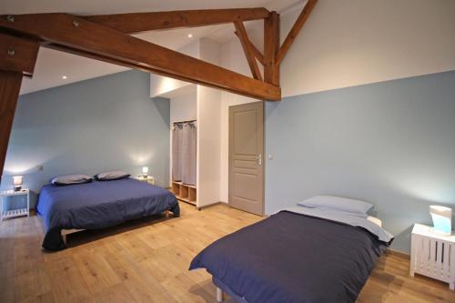 two beds in a large room with wooden beams at La reille in Cussac