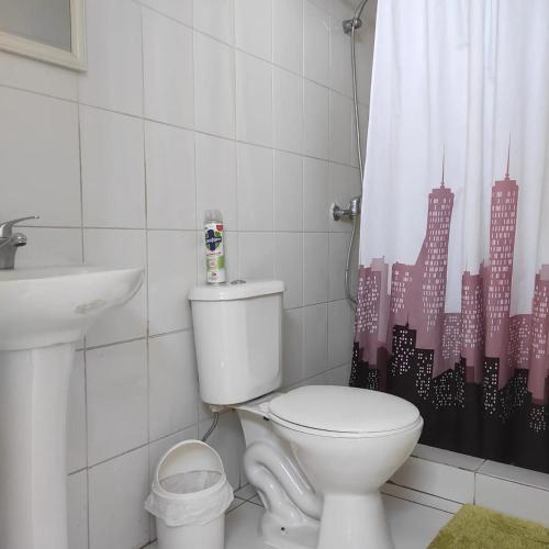 a bathroom with a toilet and a sink and a shower curtain at Iquique Beachfront -frente a playa Cavancha- in Iquique