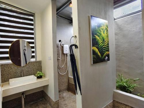 a bathroom with a shower and a painting on the wall at Borneo Nature Lodge 2 in Kinabatangan