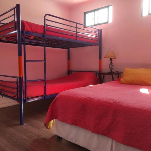 a bedroom with two bunk beds and a red bed at Iquique Beachfront -frente a playa Cavancha- in Iquique