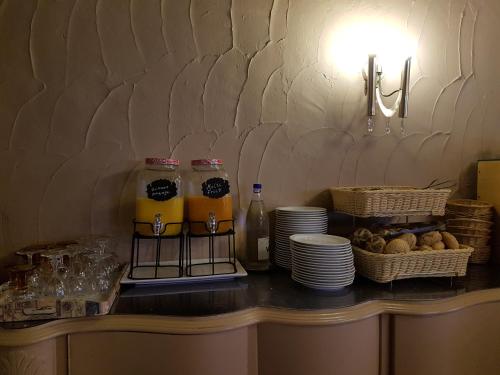 a counter with plates and drinks and baskets of food at Hostellerie Daiseldaele in Dadizele