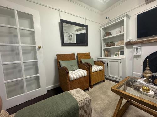a living room with two chairs and a fireplace at Pet Friendly Acer Arena Accommodation in Sydney