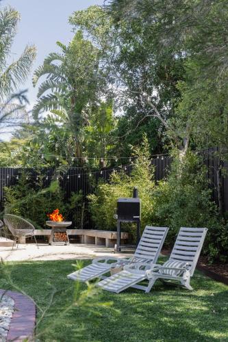 two lawn chairs sitting in a yard with a grill at The Pool House in Rosebud