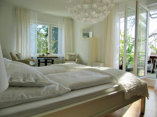 ein Schlafzimmer mit einem großen weißen Bett und einem Kronleuchter in der Unterkunft Ferienwohnung Seepromenade in Konstanz