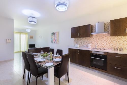 a kitchen and dining room with a table and chairs at North Side Apartment 1 in Mġarr
