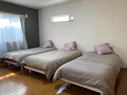 zwei Betten in einem Zimmer mit Fenster in der Unterkunft Bon Clair in Sunagawa