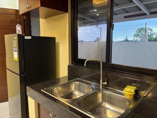 a kitchen with a stainless steel sink and a refrigerator at Three Bedrooms Two Storey Home with Parking in Santa Rosa