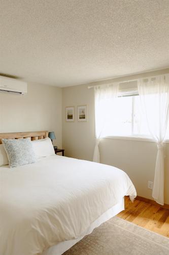 a bedroom with a white bed and a window at Paradise Creek Cottage in Moscow