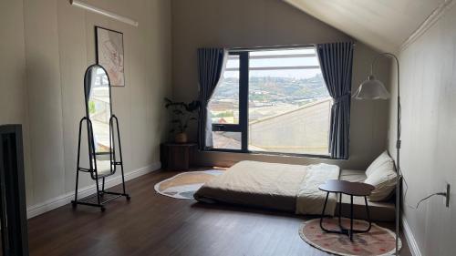 a bedroom with a bed and a large window at Nhà bạn Nhí in Khu Chi Lăng