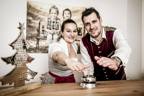 a man and a woman sitting at a table with a drink at Landhotel Berger in Eben im Pongau